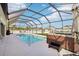 Private screened-in pool area with a hot tub and an umbrella covered table at 5269 Red Coral Cir, Mount Dora, FL 32757