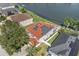 Aerial view of a two-story home with solar panels, green lawn, fenced yard, and pond at 5314 Adair Oak Dr, Orlando, FL 32829