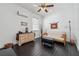 Neutral bedroom featuring dark laminate flooring, light-colored futon, and natural wood dresser at 5314 Adair Oak Dr, Orlando, FL 32829