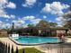 Inviting community pool with clear blue water, surrounded by well-maintained landscaping and brick buildings at 5325 Curry Ford Rd # B201, Orlando, FL 32812