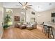 Bright living room with a leather sofa, ceiling fan, and large windows offering natural light at 5477 Glen Oak Pl, Sanford, FL 32771