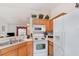 Bright eat-in kitchen features a double sink, white appliances, and wooden cabinetry at 760 Mentmore Cir, Deltona, FL 32738