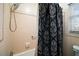 Close up of tile shower and blue patterned shower curtain in the home's bathroom space at 803 N Shore Dr, Leesburg, FL 34748