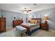 Bright bedroom featuring a patterned quilt, wooden furniture, and ample natural light at 803 N Shore Dr, Leesburg, FL 34748