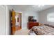 Comfortable bedroom featuring a queen-sized bed, dark wood dresser, and view to the hallway at 803 N Shore Dr, Leesburg, FL 34748