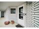 Close-up of a white brick home entrance with a sleek white door and modern hardware at 803 N Shore Dr, Leesburg, FL 34748