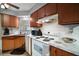 Traditional kitchen featuring wood cabinets, white appliances and tile countertops near window at 803 N Shore Dr, Leesburg, FL 34748