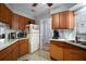 Functional kitchen with wood cabinets, white appliances and ample counter space for cooking and storage at 803 N Shore Dr, Leesburg, FL 34748