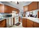 Cozy kitchen featuring wood cabinetry, white appliances, and a tiled backsplash at 803 N Shore Dr, Leesburg, FL 34748