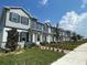 A street view of newly built townhomes featuring multi-tone exteriors, well-manicured lawns and sidewalks at 804 Pointe Emerson Blvd, Apopka, FL 32703