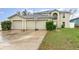 Two-story home with a three-car garage and a basketball hoop in the driveway at 9532 Water Fern Cir, Clermont, FL 34711