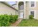 Two-story home with a white front door, side windows and manicured landscaping at 9532 Water Fern Cir, Clermont, FL 34711