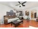 View of the living room featuring hardwood floors, ceiling fan, two couches and view to kitchen at 9532 Water Fern Cir, Clermont, FL 34711