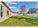 Spacious backyard featuring a green lawn and white vinyl fence for privacy at 10024 John Adams Way, Orlando, FL 32817