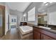 Bright bathroom features a soaking tub, dual vanities with granite countertops, and a tiled walk-in shower at 10024 John Adams Way, Orlando, FL 32817