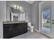 Full bathroom with dark wood cabinets and a granite countertop, plus a door to the backyard at 10024 John Adams Way, Orlando, FL 32817