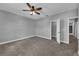 Bedroom featuring gray walls, ceiling fan, carpet, closet and attached bathroom at 10024 John Adams Way, Orlando, FL 32817