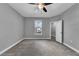 This is a bedroom with neutral colored walls, carpeted floors, a ceiling fan, and an open closet at 10024 John Adams Way, Orlando, FL 32817