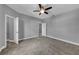 This is a bedroom with neutral colored walls, carpeted floors, ceiling fan, and multiple doors at 10024 John Adams Way, Orlando, FL 32817