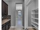 Butler's pantry with granite countertops, backsplash, and dark cabinets, and a view of the dining room at 10024 John Adams Way, Orlando, FL 32817