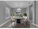 Formal dining room features neutral paint, tile floors, modern light fixture, and plantation shutters at 10024 John Adams Way, Orlando, FL 32817