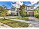 Inviting two-story home boasting a brick driveway, attached garage, and well-manicured landscaping at 10024 John Adams Way, Orlando, FL 32817