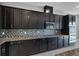 Close up of kitchen with granite countertops, dark wood cabinets, and stainless steel appliances at 10024 John Adams Way, Orlando, FL 32817