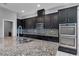 Modern kitchen with stainless steel appliances, double oven, and granite countertops at 10024 John Adams Way, Orlando, FL 32817