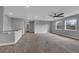 Open concept living room with neutral carpet, ceiling fan, and natural light from large windows at 10024 John Adams Way, Orlando, FL 32817