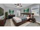 This is a spacious main bedroom featuring a plush rug, ceiling fan, and artwork above the bed and dresser at 10024 John Adams Way, Orlando, FL 32817