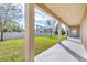 Covered patio overlooking a well-maintained lawn with a white fence in the background at 10024 John Adams Way, Orlando, FL 32817