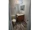 Bathroom featuring a wood vanity, mirror, and stylish wood-look flooring at 1004 Travertine Ter, Sanford, FL 32771