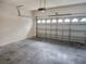 Spacious garage featuring a concrete floor, white walls, and a metal garage door at 1004 Travertine Ter, Sanford, FL 32771