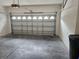 Spacious garage with white walls, concrete floor, and metal garage door with windows at 1004 Travertine Ter, Sanford, FL 32771