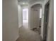 Spacious hallway featuring neutral carpet, white walls, and arched doorways at 1004 Travertine Ter, Sanford, FL 32771