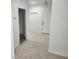 Bright hallway with white walls, tile flooring, and carpet adding warmth to this inviting residence at 1004 Travertine Ter, Sanford, FL 32771