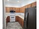 Functional kitchen featuring oak cabinets, modern appliances, and durable flooring at 1004 Travertine Ter, Sanford, FL 32771