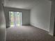 Bright living room featuring neutral carpet and sliding door access to the outside at 1004 Travertine Ter, Sanford, FL 32771