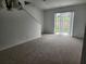 Bright living room featuring neutral carpet and sliding door access to the outside at 1004 Travertine Ter, Sanford, FL 32771