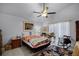 Bright bedroom featuring tiled floors, a ceiling fan, and a cozy rocking chair for added comfort at 10809 Oak Glen Cir, Orlando, FL 32817