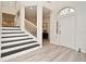 Bright foyer with white walls, light wood floors, staircase and large front door with side window at 1215 Castleport Rd, Winter Garden, FL 34787