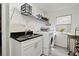 Bright laundry room features a stainless steel sink, black granite countertop and modern appliances at 1215 Castleport Rd, Winter Garden, FL 34787