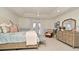 Bright bedroom with large bed, tray ceiling, French doors, dresser, and an ornate mirror at 1215 Castleport Rd, Winter Garden, FL 34787