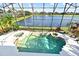 The screened in pool area offers a lovely view of the lake and the property's lush landscaping at 1215 Castleport Rd, Winter Garden, FL 34787