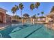 Community swimming pool surrounded by lounge chairs, fencing, and palm trees under a clear blue sky at 13500 Turtle Marsh Loop # 816, Orlando, FL 32837