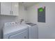 Laundry room with washer, dryer, and white cabinetry for ample storage space at 1518 Fabian Ave, Orlando, FL 32807