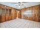 Spacious bedroom featuring wood-paneled walls, tile flooring, and a ceiling fan at 1606 The Oaks Dr, Maitland, FL 32751