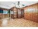 Bedroom featuring wood paneling, built-in shelving, laminate flooring, and a ceiling fan at 1606 The Oaks Dr, Maitland, FL 32751