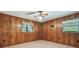 Bedroom with wood paneled walls, tile flooring, and natural light from two windows at 1606 The Oaks Dr, Maitland, FL 32751