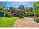 Charming two-story home featuring a brick driveway and lush landscaping at 1606 The Oaks Dr, Maitland, FL 32751